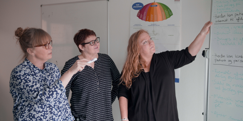 Tre kvinder som kigger på en tavle